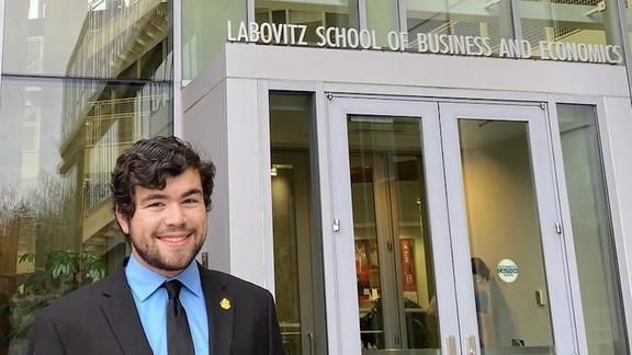 Braden Nissen standing in front of Labovitz School of Business and Economics