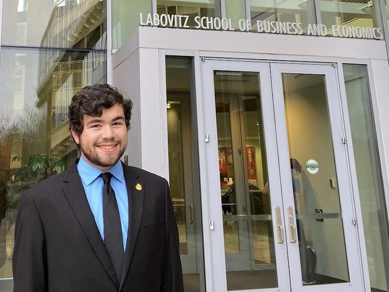Braden Nissen standing in front of Labovitz School of Business and Economics