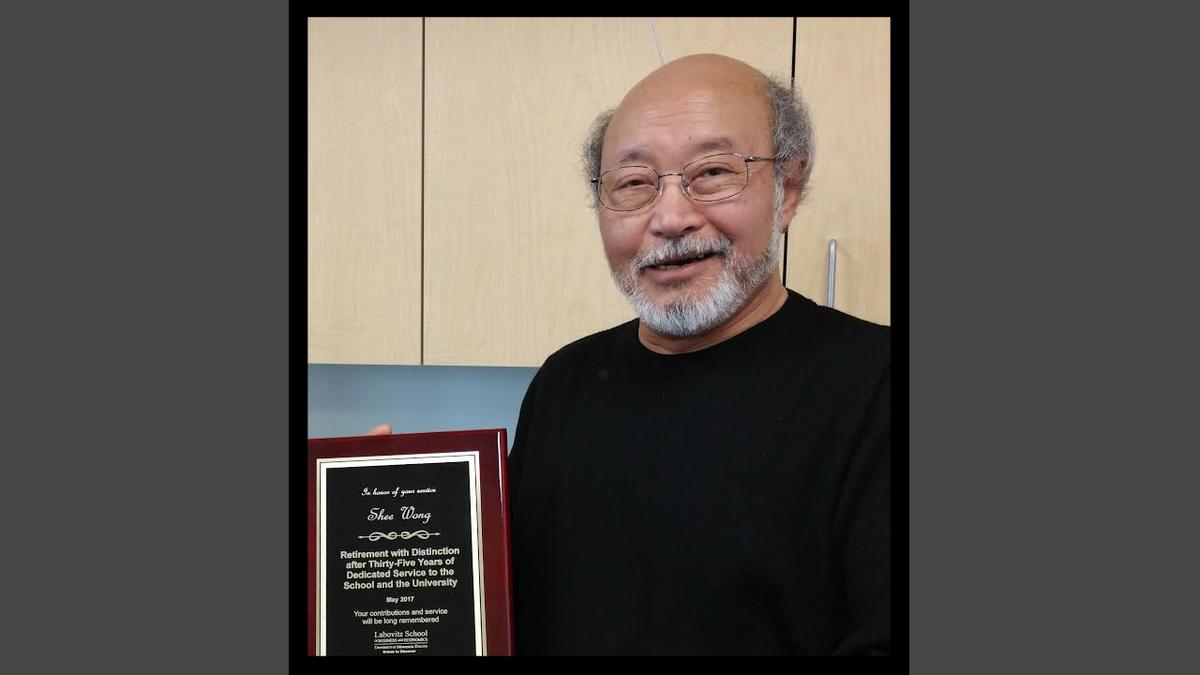 Dr. Shee Wong with a plaque 