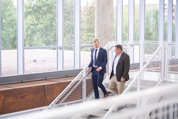 Aiden Kray walks down stairs with Economics Professor Neil Wilmot. 